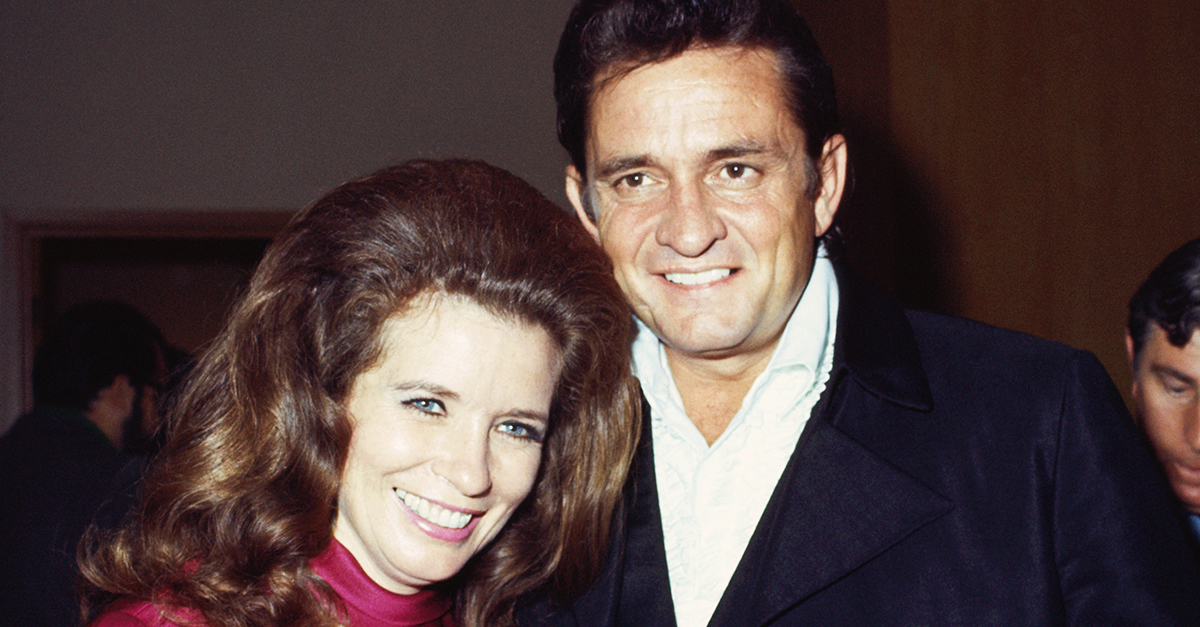 Country singers Johnny Cash and June Carter smiling together.