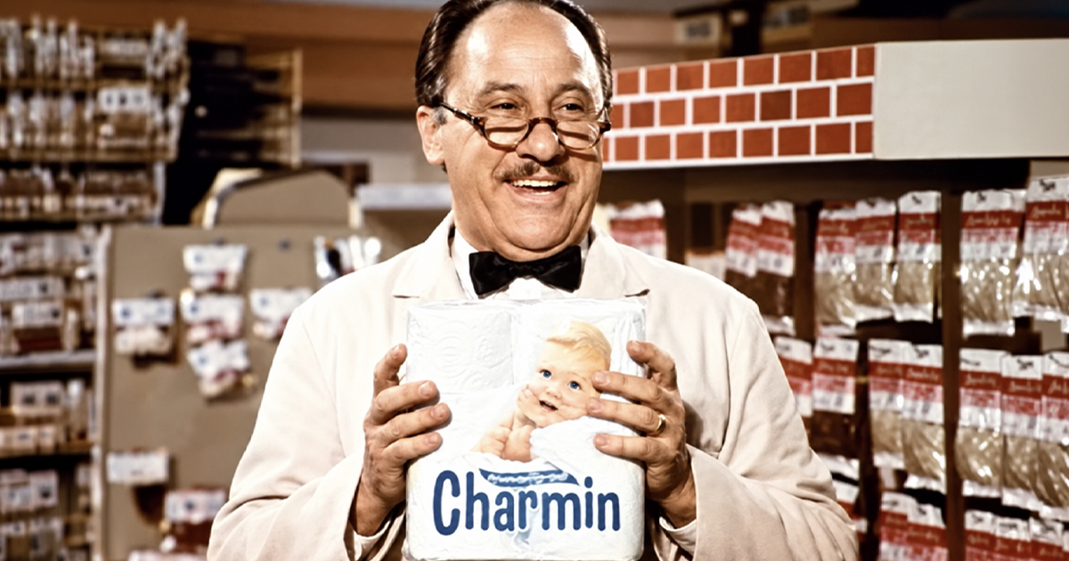 A grocery store clerk holding toilet paper