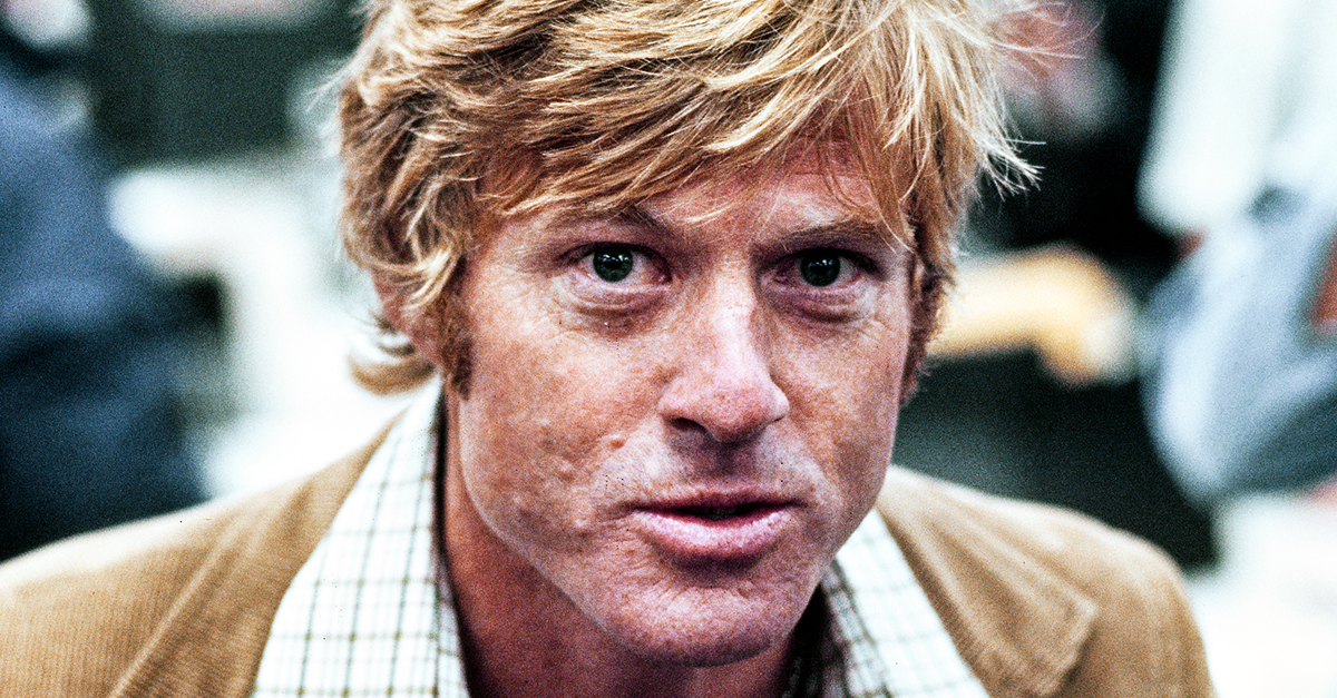 American actor Robert Redford, wearing a brown corduroy blazer over a checked shirt, in a recreation of The Washington Post's offices, on the set of 'All the President's Men,' filmed at Burbank Studios in Burbank, California, 1976. The political thriller based on the Watergate scandal, directed by Alan J Pakula, starred Redford as Bob Woodward.