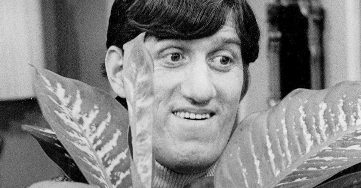 Photo of Paul Benedict with a plant.