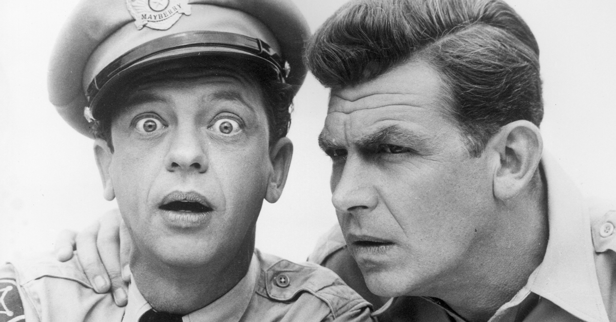 American actor Don Knotts looks at the camera with a surprised expression, as Andy Griffith holds his hand on his shoulder, posing in character as Deputy Barney Fife and Sheriff Andy Taylor